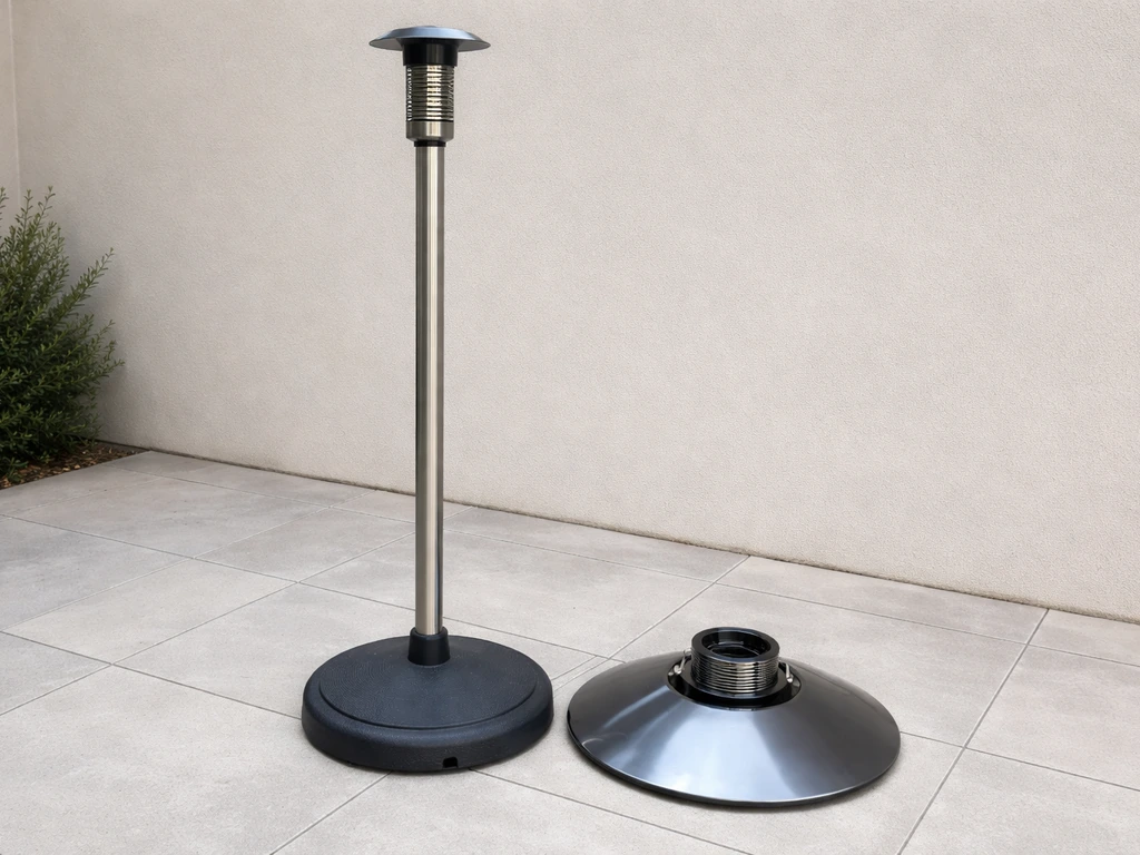 Electric freestanding patio heater upright on patio surface with upper housing parts laid nearby